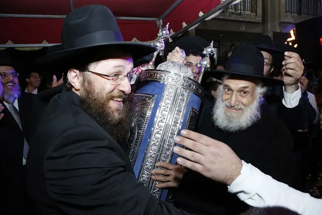 שני דורות מחזיקים יחד את ספר התורה החדש
